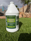 Bottle of turf odor eliminator cleaner on turf with outdoor background